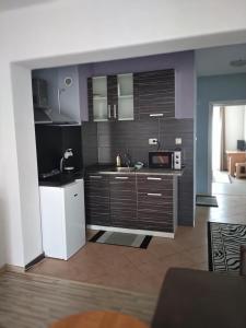 a kitchen with brown cabinets and a white refrigerator at Vila Nova in Sandanski