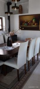 ein Esszimmer mit einem Tisch und weißen Stühlen in der Unterkunft Mavridis House in Eleftheroúpolis