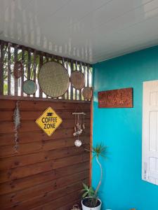 Habitación azul con un letrero de café en la pared en Caze bois flotté, en Petite Île