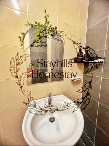 a bathroom with a sink with plants on the wall at Astana Townhouse Homestay BukitBeruntung livingroom AirCond in Kampung Sungia Buaya