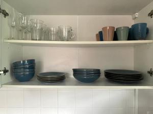a shelf with blue bowls and plates on it at Im Herzen von Barsinghausen in Barsinghausen