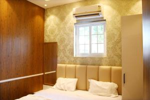 um quarto com uma cama e uma janela em The Hotel Ambassador Inn em Varanasi