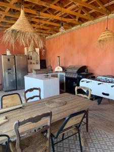 eine große Küche mit einem Holztisch und Stühlen in der Unterkunft Chambre d’hôtes Mazet Les Abadies in Saint-Félix-de-Lodez