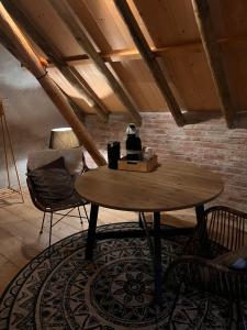 uma mesa e cadeiras num quarto com uma parede de tijolos em B&B Oldenbosch em Holwierde
