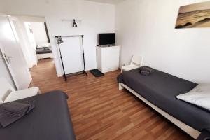 a bedroom with a bed and a television in it at Work & Stay 3 Room Apartment in Plettenberg