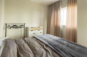 a white bedroom with a bed and a window at Beautiful apartment next to the Kalev Stadium in Tallinn