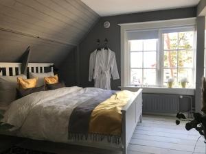 1 dormitorio con cama y albornoz colgado en una ventana en Huize Villa Vos en Hellendoorn