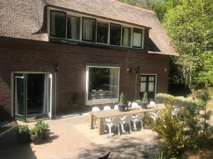 un patio con mesa y sillas frente a un edificio en Huize Villa Vos en Hellendoorn