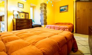 パレルモにあるカサ カリオストロ パレルモの黄色のベッドルーム(ベッド2台、ドレッサー付)