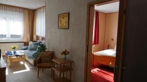 a living room with a couch and a bed at Gästehaus Fehrenbacher Schweiz in Masserberg