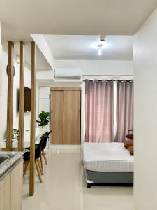 1 dormitorio con cama, escritorio y cocina en Condo Saga Davao City en Dávao