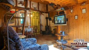a living room with a couch and a tv at Arode Hütte Harzilein - Romantic tiny house on the edge of the forest in Zorge