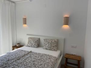 a bedroom with a bed with two pillows and two lights at Casa Avellana 37 in Denia