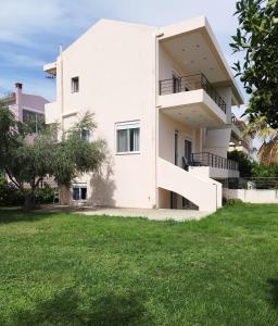 a white house with a green yard at Sunkissed and Seasalted House in Melission