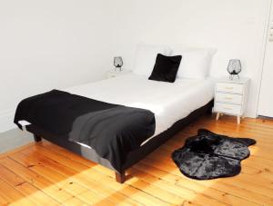 - une chambre avec un lit blanc et une couverture noire dans l'établissement Appartement Cosy, à Poissy