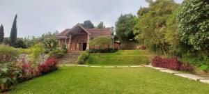 ein Haus mit einem grünen Garten in der Unterkunft Villa Jati in Cimandala