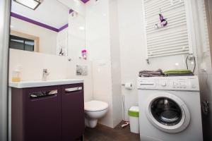 a bathroom with a washing machine and a toilet at Extra Green Kabaty Apartament nr 5 in Warsaw