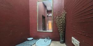ein rotes Badezimmer mit einem Waschbecken und einem Spiegel in der Unterkunft Villa Jati in Cimandala + 14 Fotos