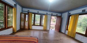 ein leeres Zimmer mit Fenstern und einem Bett darin in der Unterkunft Villa Jati in Cimandala