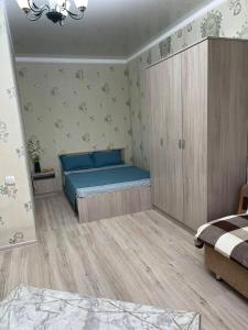 um quarto com uma cama azul e um armário em 1-комнатная квартира в центре em Kokshetau