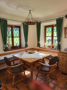 uma sala de jantar com mesa, cadeiras e janelas em Ferienwohnung am Fuschlsee em Fuschl am See