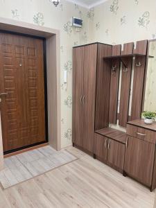 łazienka z drewnianymi szafkami i drzwiami w obiekcie 1-комнатная квартира в центре w mieście Kokczetaw