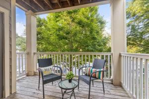 a porch with chairs and a table and a tree at Lovely 1-bedroom apartment w/ Pool + Wi-Fi in Charlotte