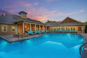 a swimming pool with blue chairs in front of a house at Lovely 1-bedroom apartment w/ Pool + Wi-Fi in Charlotte
