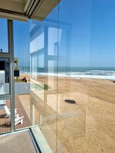 una casa de cristal con vistas a la playa en Henties Bay Haven Holiday Home, en Henties Bay