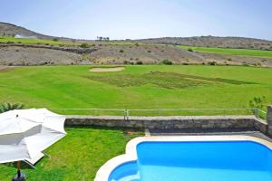 マスパロマスにあるSalobre Vista Golf 29のプールとパラソル付きのゴルフコースのオーバーヘッドビュー