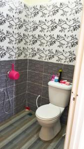 a bathroom with a toilet and a black and white wallpaper at Homestay Dena Moon Inn in Tumpat
