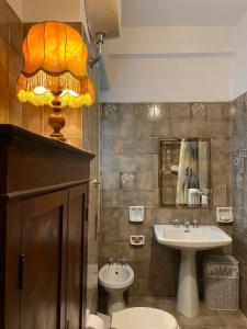 baño con lavabo, aseo y lámpara en Semini di nostalgia, en Roma