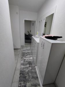 a kitchen with white cabinets and a rug on the floor at Apartment Emina in Tuzla
