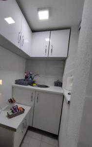 a small kitchen with white cabinets and a sink at Apartment Emina in Tuzla