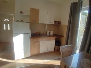 a kitchen with a white refrigerator and a table at Apartman Aleksandar Aco in Herceg-Novi