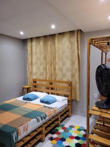 um quarto com uma cama de madeira e uma ventoinha em Aluguel Temporada em Martins/RN em Martins