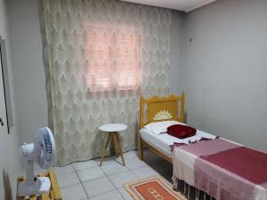 een kleine slaapkamer met een bed en een raam bij Aluguel Temporada em Martins/RN in Martins
