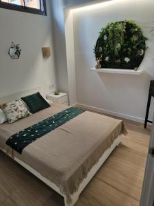 a bedroom with a bed with a plant on the wall at Las Artes Hlius Luxury Apartments in Valencia