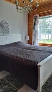 a large bed in a room with a window at Mäntyniemi in Petäjävesi