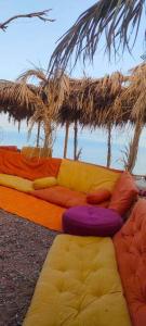 a bunch of pillows and a couch on the ground at Fully equipped Remote off-grid Solar Wooden Home in Dahab