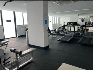 a gym with several treadmills and machines at Comfortable Living - NO PARTIES- 3 Bedroom sleeps 6, parking, pool, other amenities - Near Showgrounds in Sydney