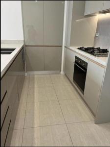 a kitchen with white cabinets and a stove at Comfortable Living - NO PARTIES- 3 Bedroom sleeps 6, parking, pool, other amenities - Near Showgrounds in Sydney