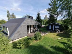 een klein huis met een veranda en een tuin bij Eifel Residence 2 in Gerolstein