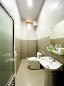 Ấp Ða LợiにあるMini Homeのバスルーム(洗面台、トイレ、鏡付)