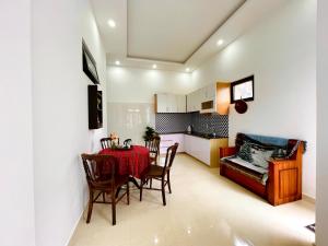 uma cozinha e sala de jantar com mesa e cadeiras em Mini Home em Ấp Ða Lợi