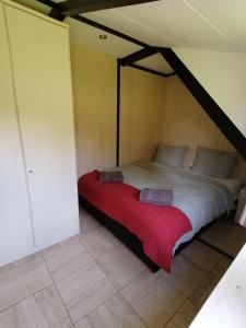 - une chambre avec un grand lit et une couverture rouge dans l'établissement Eifel Residence 2, à Gerolstein