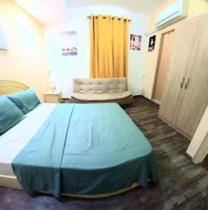 - une chambre avec un grand lit et un rideau jaune dans l'établissement Appartment Camellia, à Flic-en-Flac