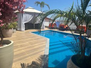 a swimming pool on a wooden deck with chairs and plants at Hotel Pousada Irmaos Freyhardt in Rio de Janeiro