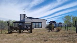 a building with a fence and a gate and a building at HERMOSA CASA 2 DORMITORIOS EN POTRERO DE GARAY in Potrero de Garay +8 photos
