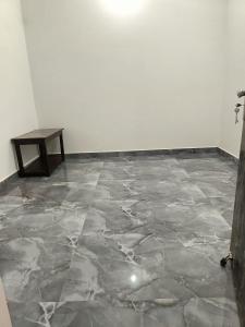 a room with a marble floor and a table at Shree Yamunaji Kripa Kunj in Gokul